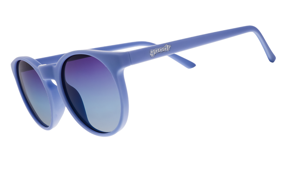Three-quarter angle view of light blue circular sunglasses with dark blue gradient lenses.