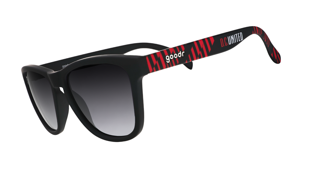 Three-quarter angle view of DC United Major League Soccer sunglasses with black and red frames and black lenses.