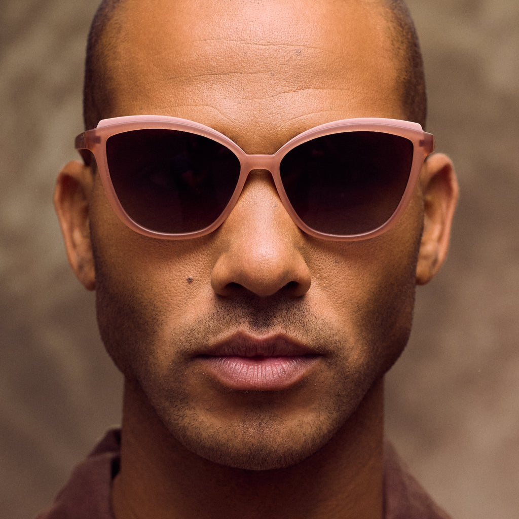 Man wearing brown sunglasses against a brown background