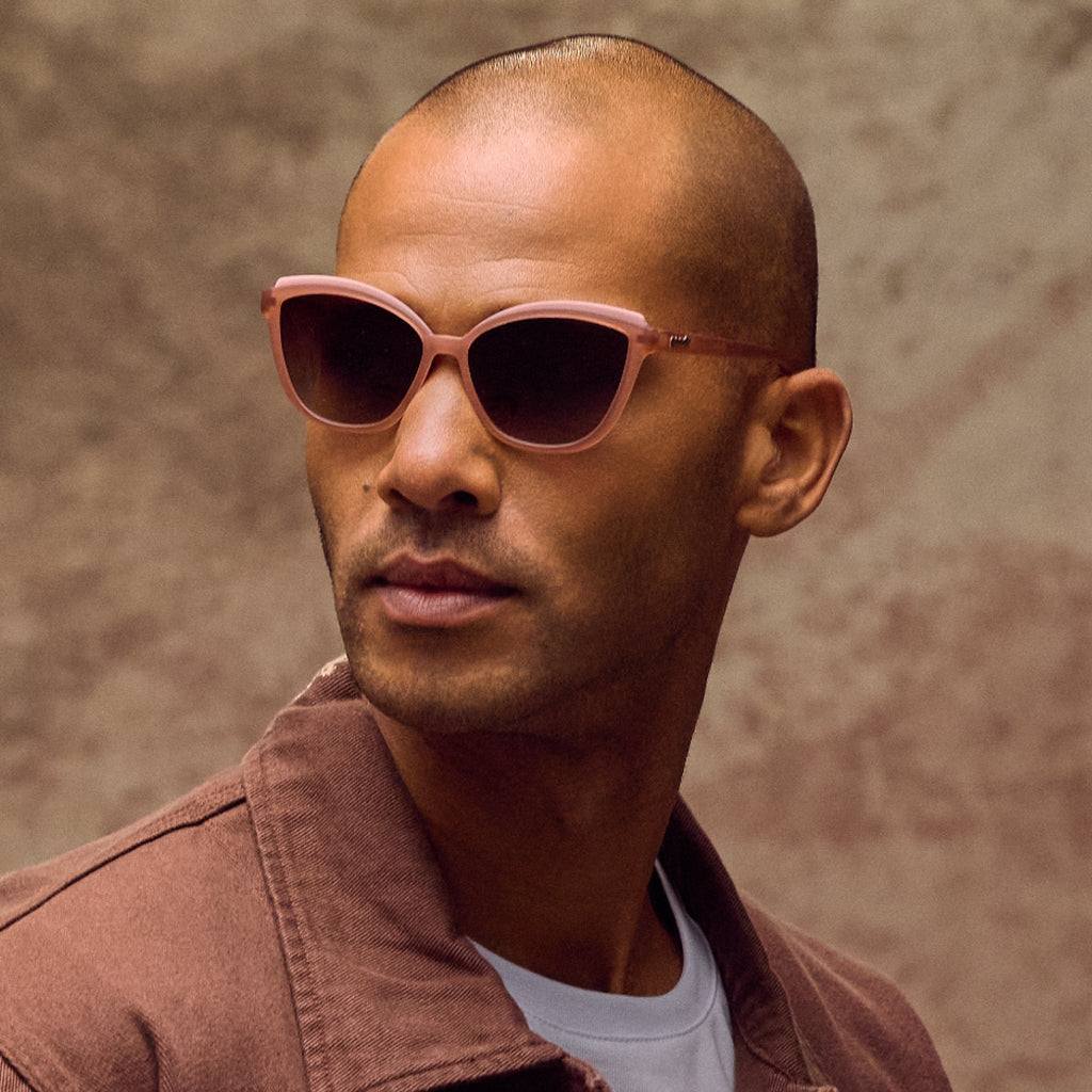 Man wearing brown sunglasses with a neutral background