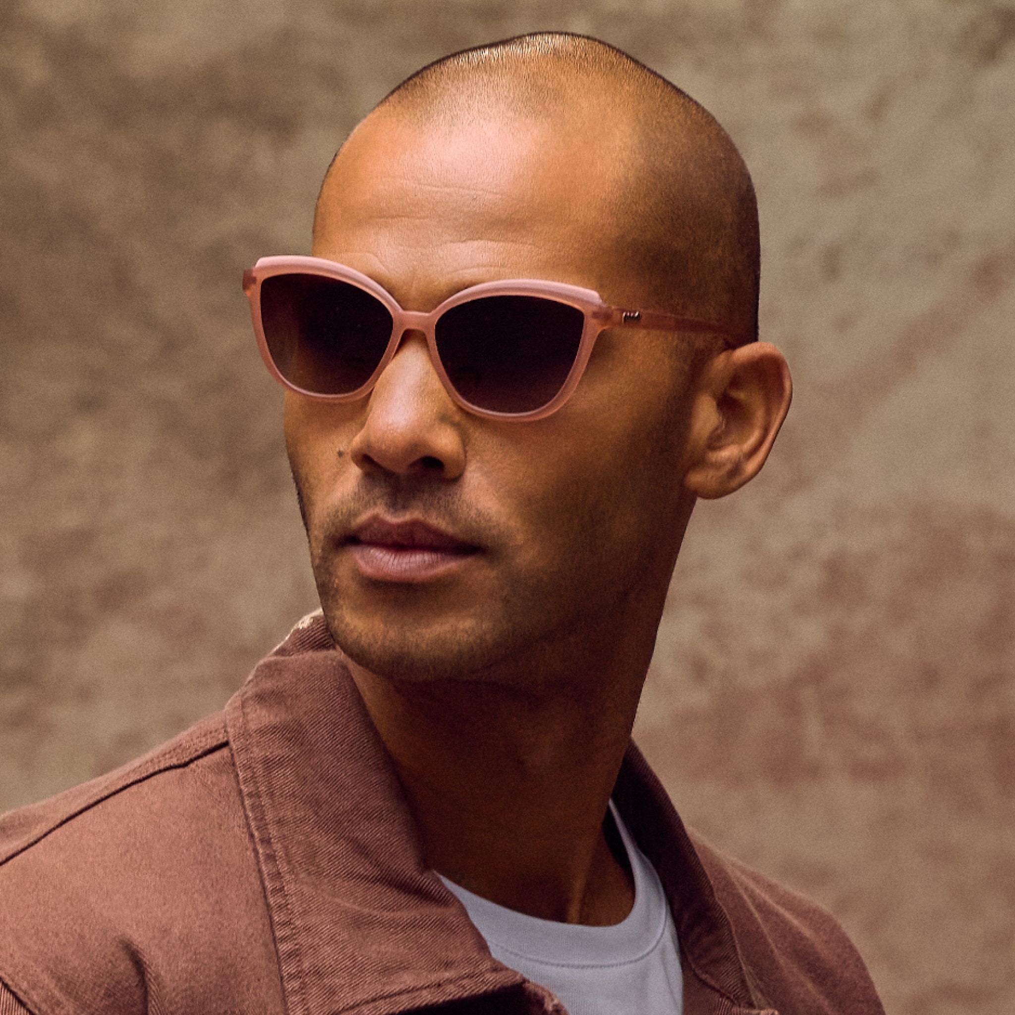 Man wearing brown sunglasses with a neutral background