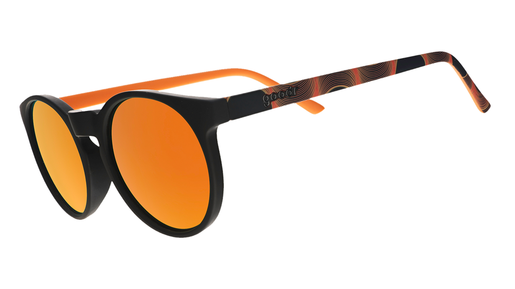 Three-quarter angle view of orange and black round sunglasses with reflective orange lenses.