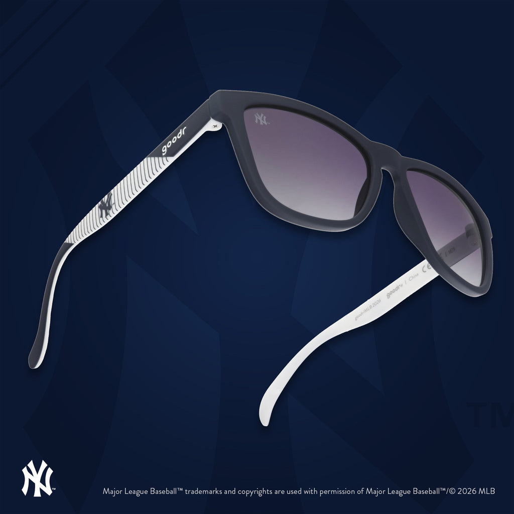 Three-quarter angle view of a pair of Mets sunnies floating against an orange background featuring the team's NY logo.