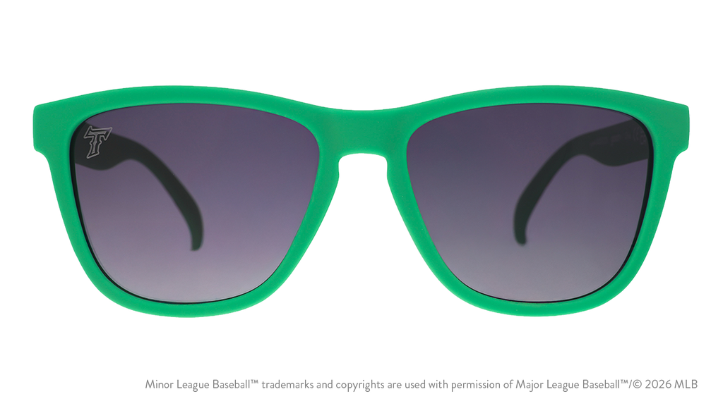 Front view of sunglasses. Solid green front frame. Black gradient lenses. Tides logo etching in top corner of lens.