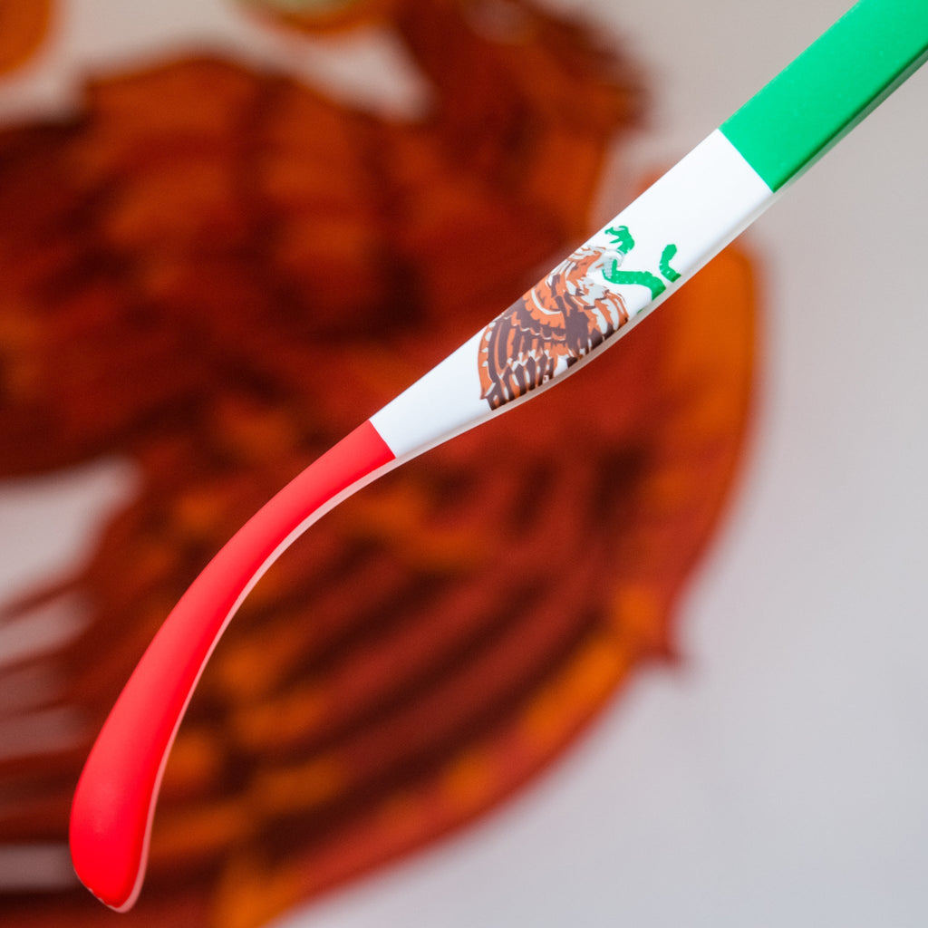 Angled view of green shades w/ a Mexican flag pattern+burnt orange reflective lenses on a stylized background.