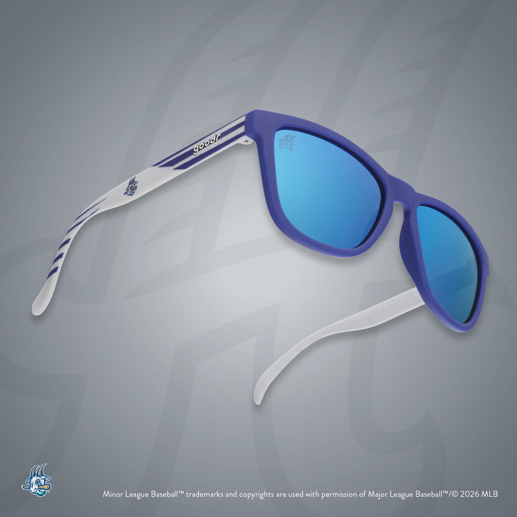 Three-quarter angle view of shades tilted up. Blue + gray frames w/ Yard Goats logo on temples. Teal reflective lenses.