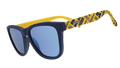 A pair of "goodr" sunglasses with navy-blue frames and reflective blue lenses. The arms of the sunglasses are bright yellow and feature University of Michigan "M" logos and text that reads "Go Blue" in a repeating pattern.
