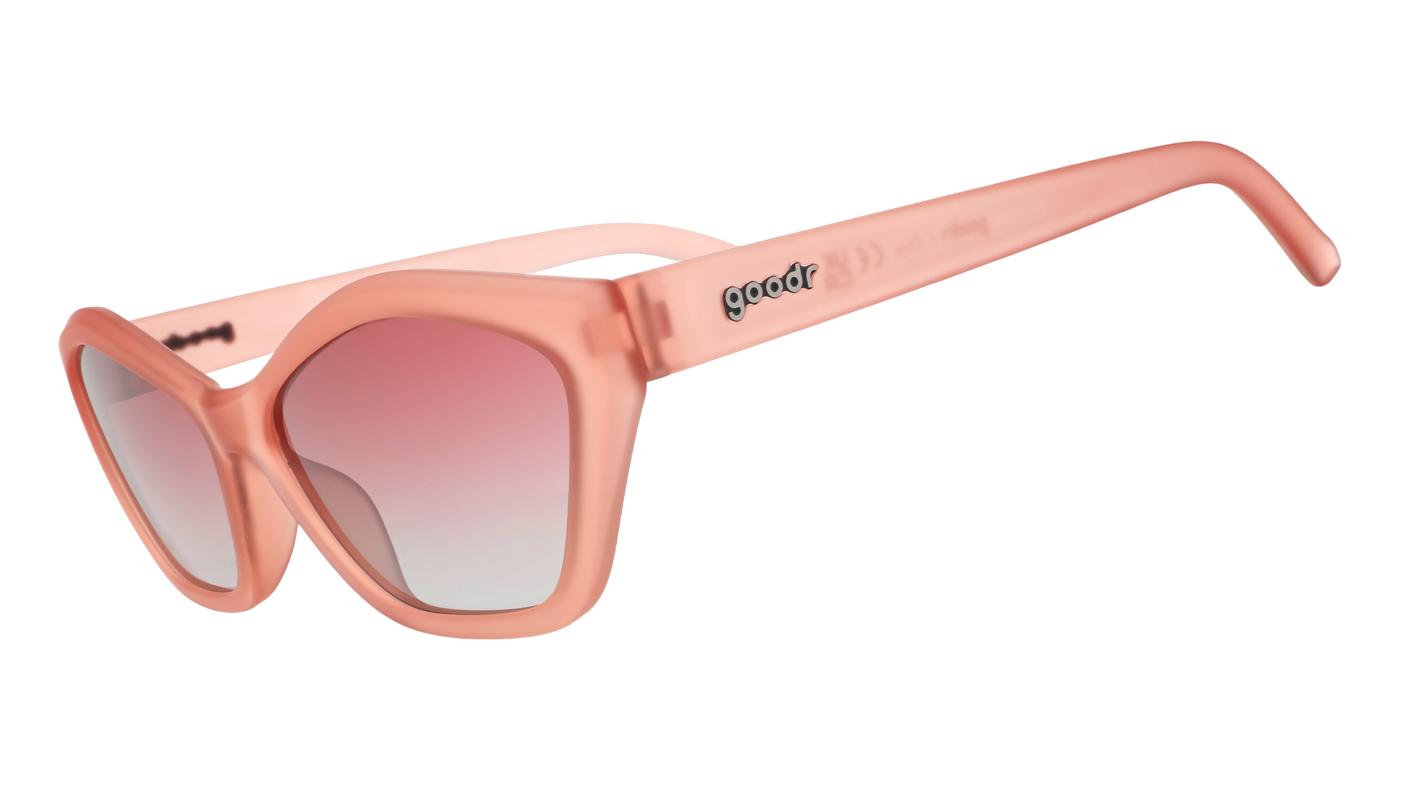 Three-quarter angle view of geometric sunglasses with translucent coral pink frames and gradient lenses against a white background.