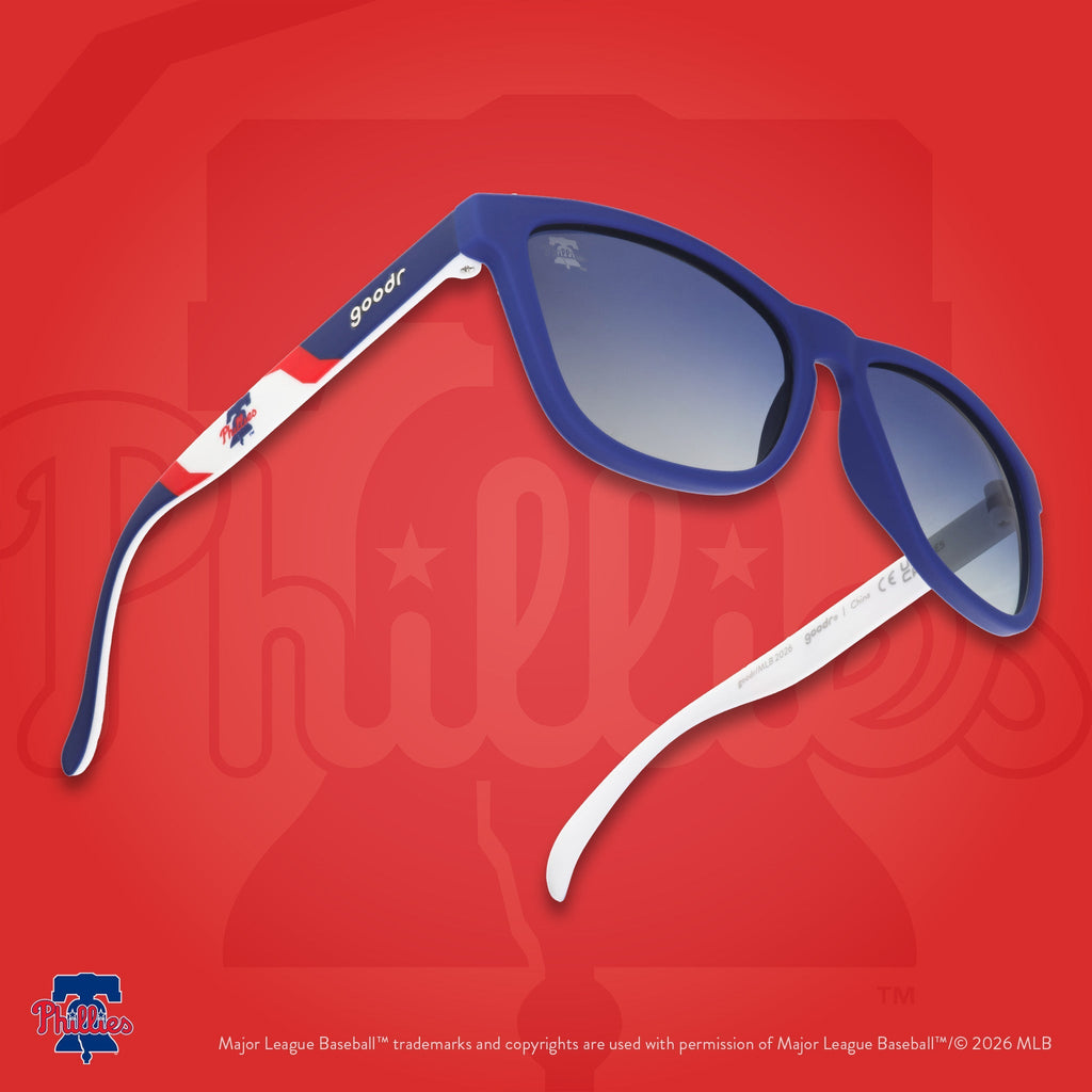 Three-quarter angle view of a pair of Phillies sunnies floating against a red background featuring the Liberty Bell logo.