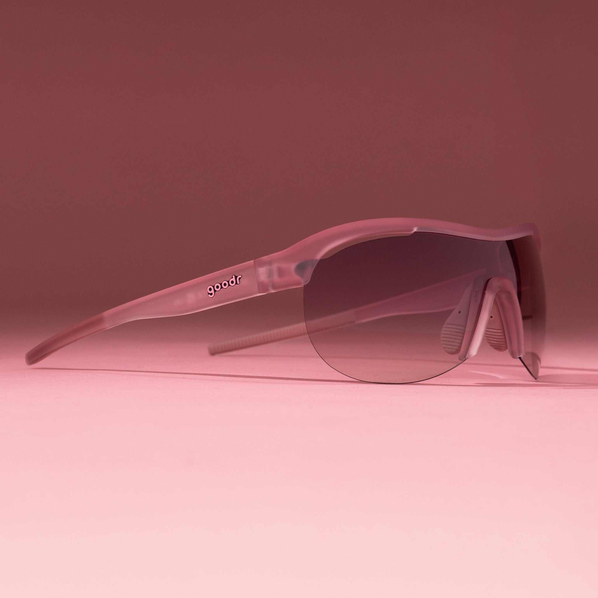 Right three-quarter angle view of translucent purple wrap shield sunglasses with gradient purple lenses on a tabletop.