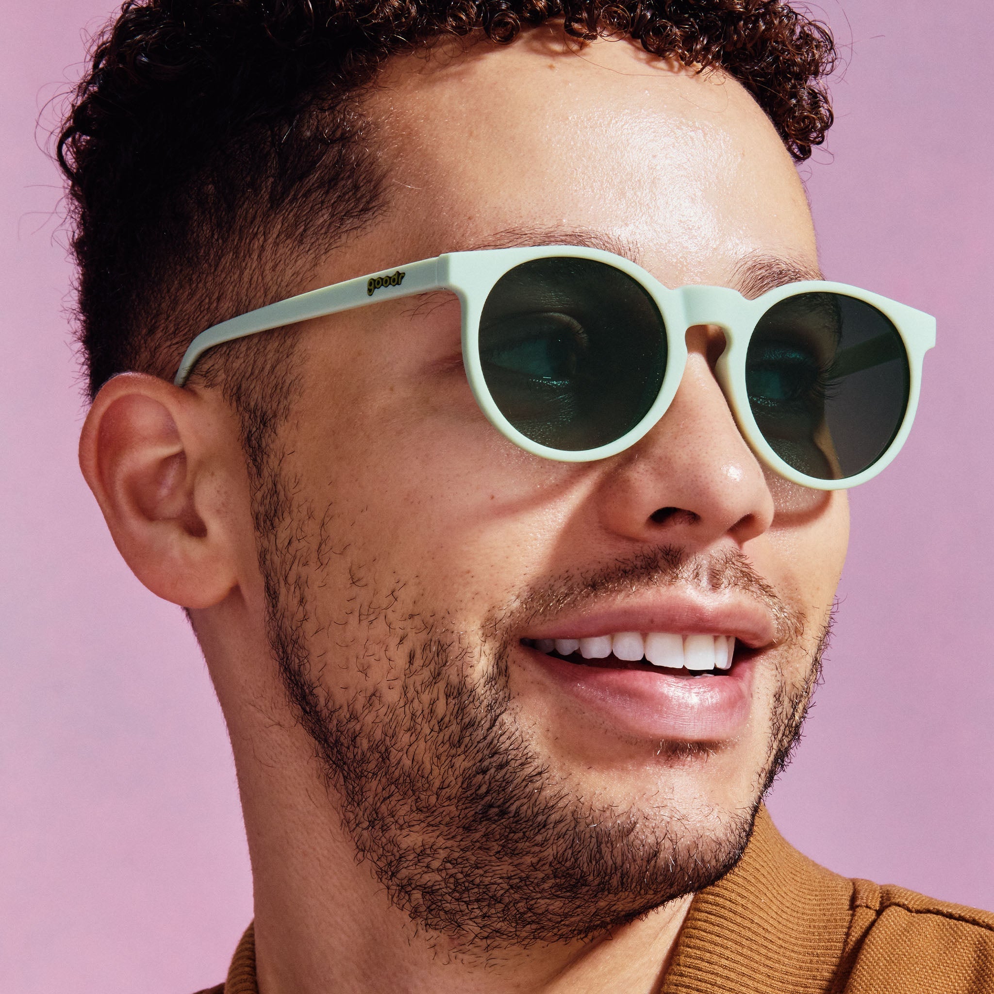 A pair of round sunglasses with mint green frames.