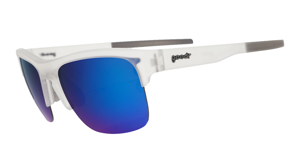 Three-quarter angle view of clear sunnies with half-rim frames+blue reflective lenses tilted down on a white background.