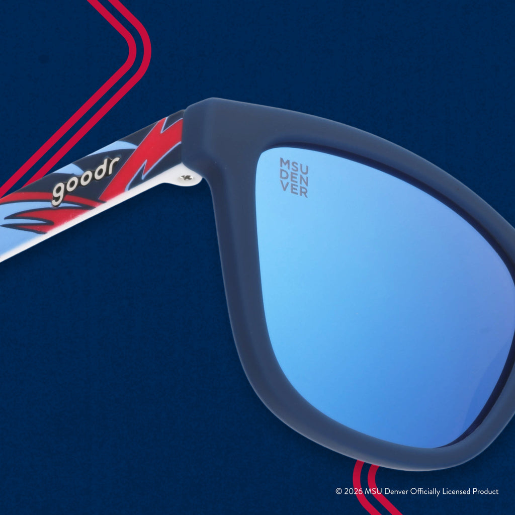 Close-up view of shades. Blue frames w/ a red+white pattern. MSU DENVER etching in top corner of blue reflective lens.