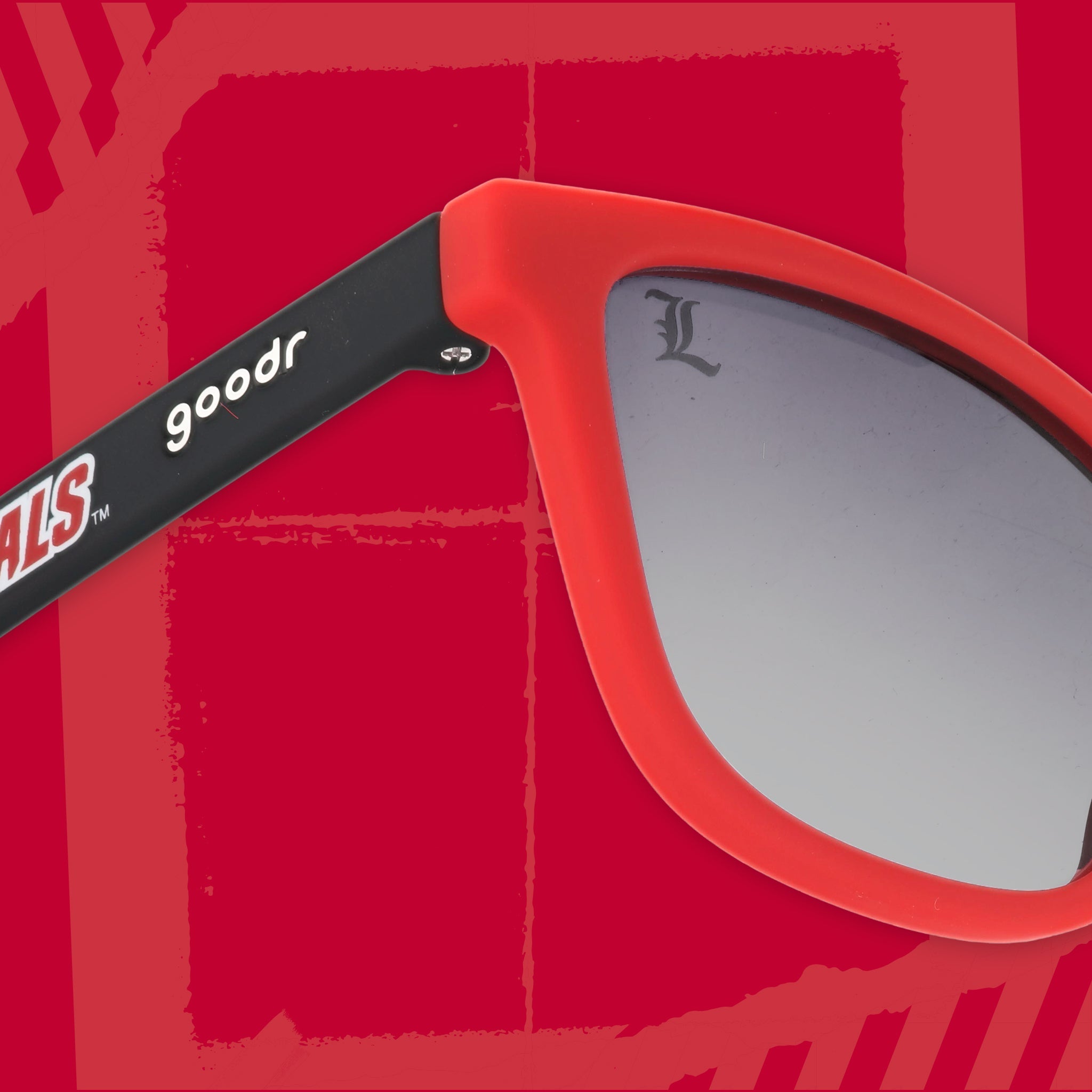 Close-up three-quarter angle view of black and Cardinal red sunglasses featuring black gradient lenses and the goodr logo on a red background.