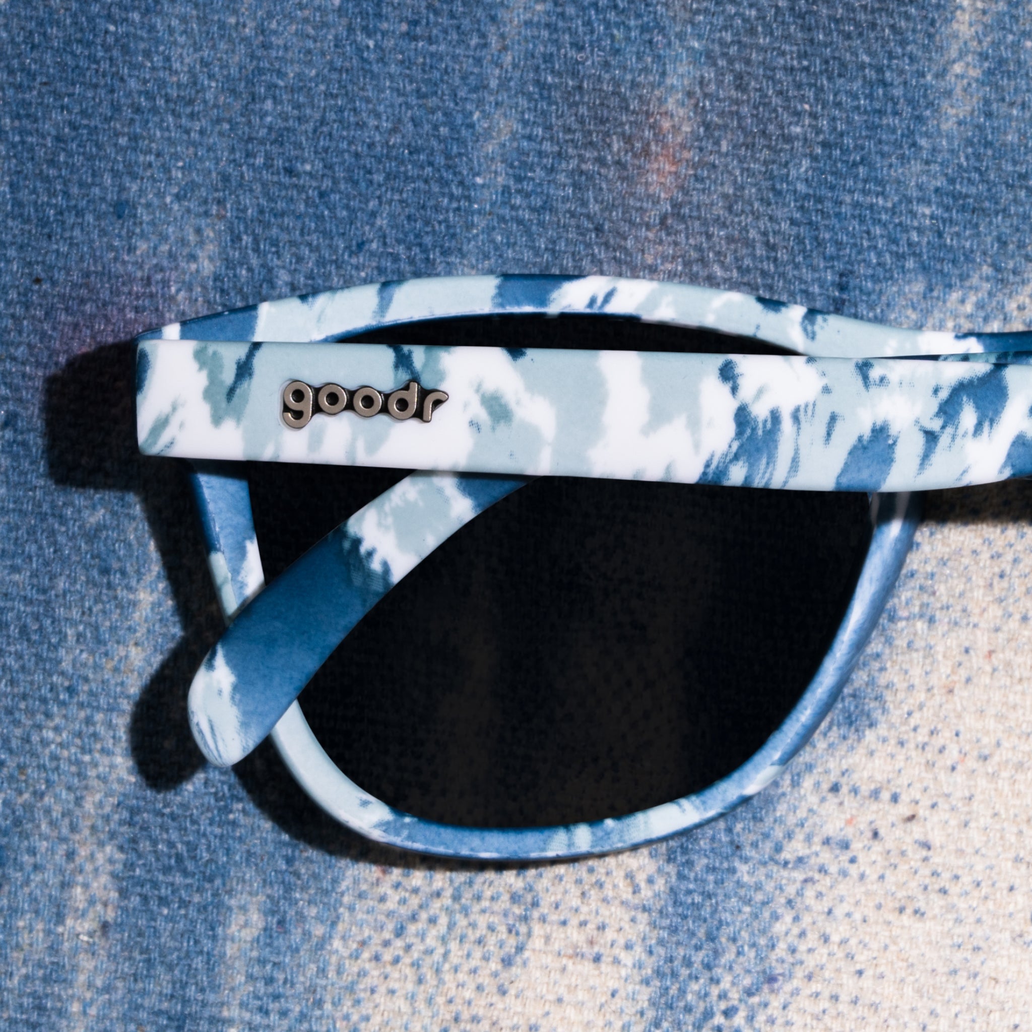 Front view of tonal blue on blue tie-dye sunglasses in a classic frame shape with ice blue reflective lenses.