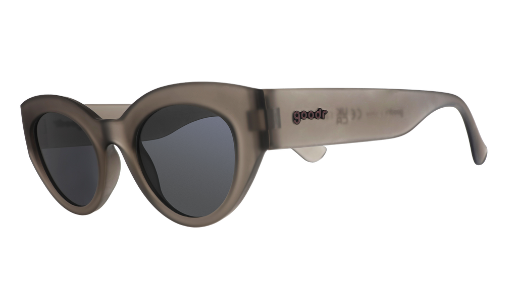 Three-quarter angle view of translucent dark gray, retro-inspired angled cat-eye sunglasses with black non-reflective lenses.