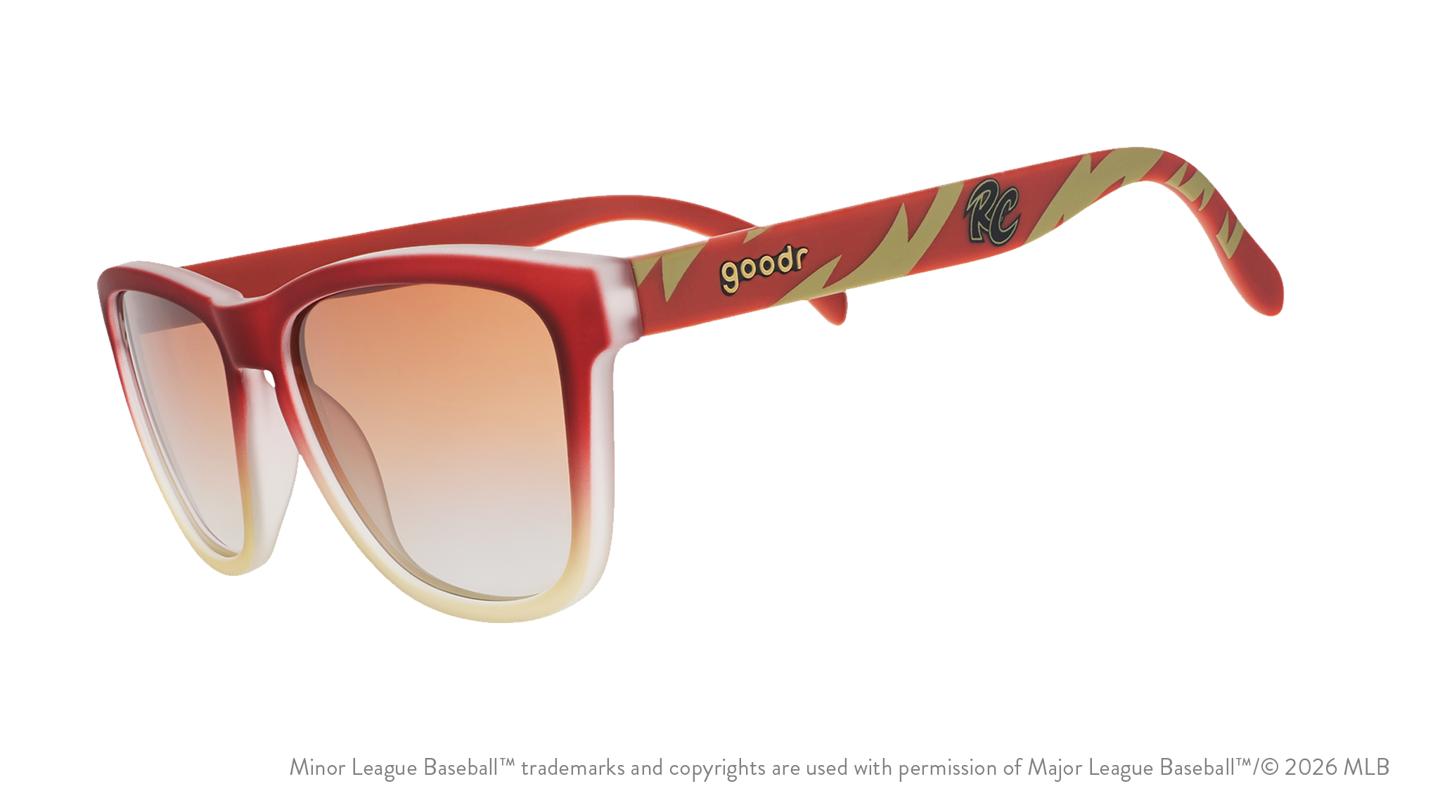 Three-quarter angle view of sunglasses tilted down. Brown + red frames w/ RC on temples + amber gradient lenses.