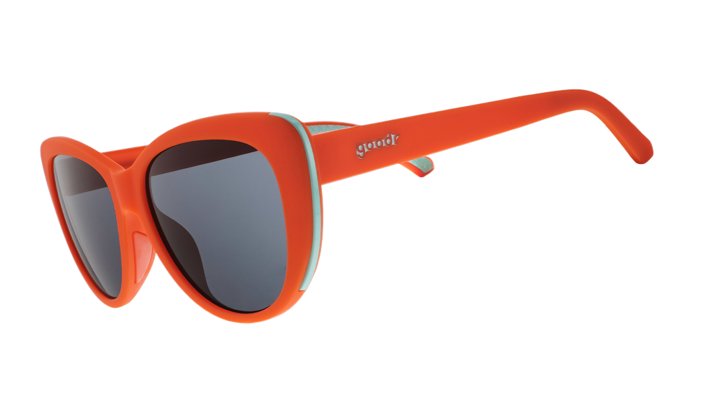 Three-quarter angle view of red cat-eye sunglasses with black non-reflective lenses.