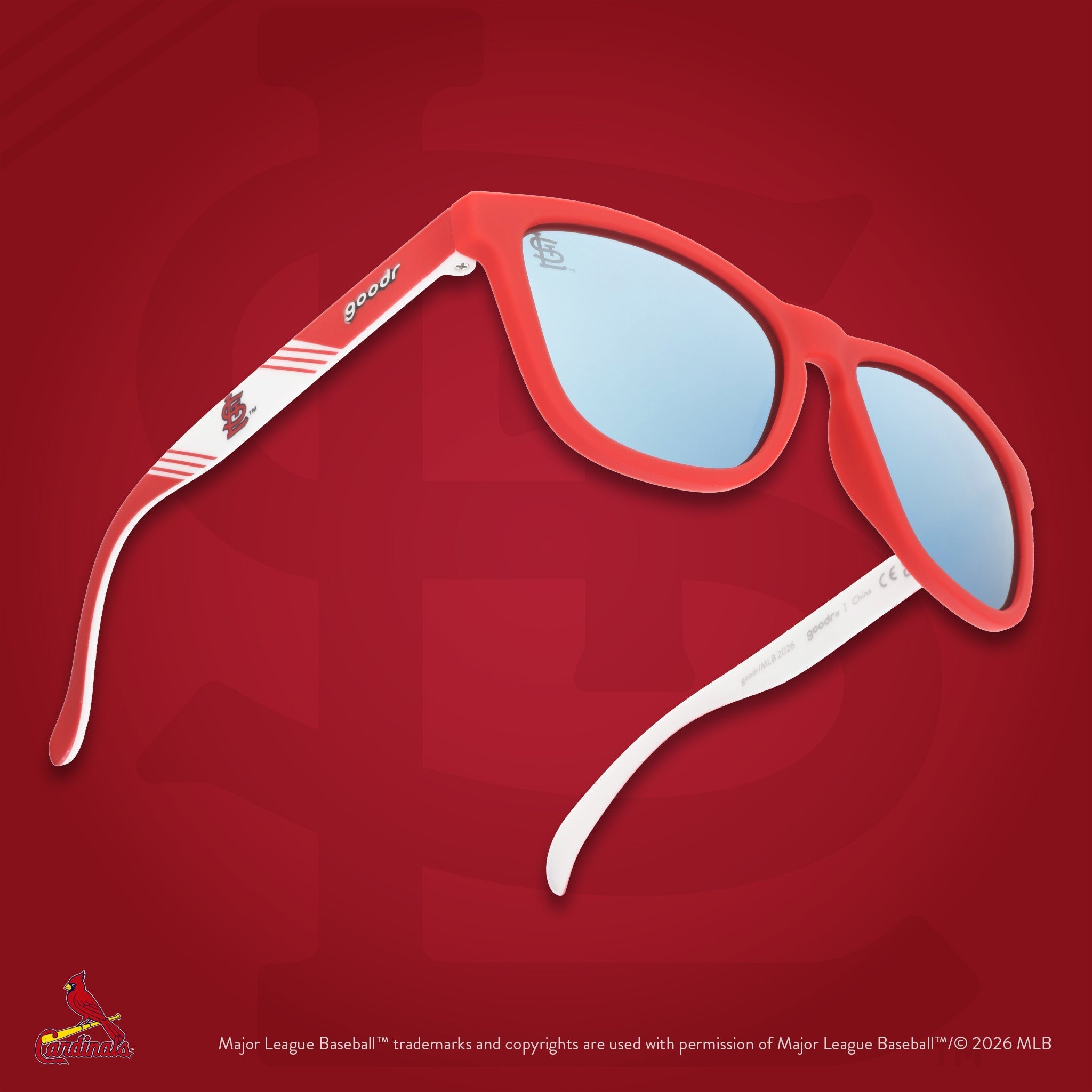 Three-quarter angle view of a pair of red and white sunglasses against a red background featuring the St. Louis StL logo.