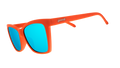 Three-quarter angle view of red angular sunglasses with blue reflective lenses.