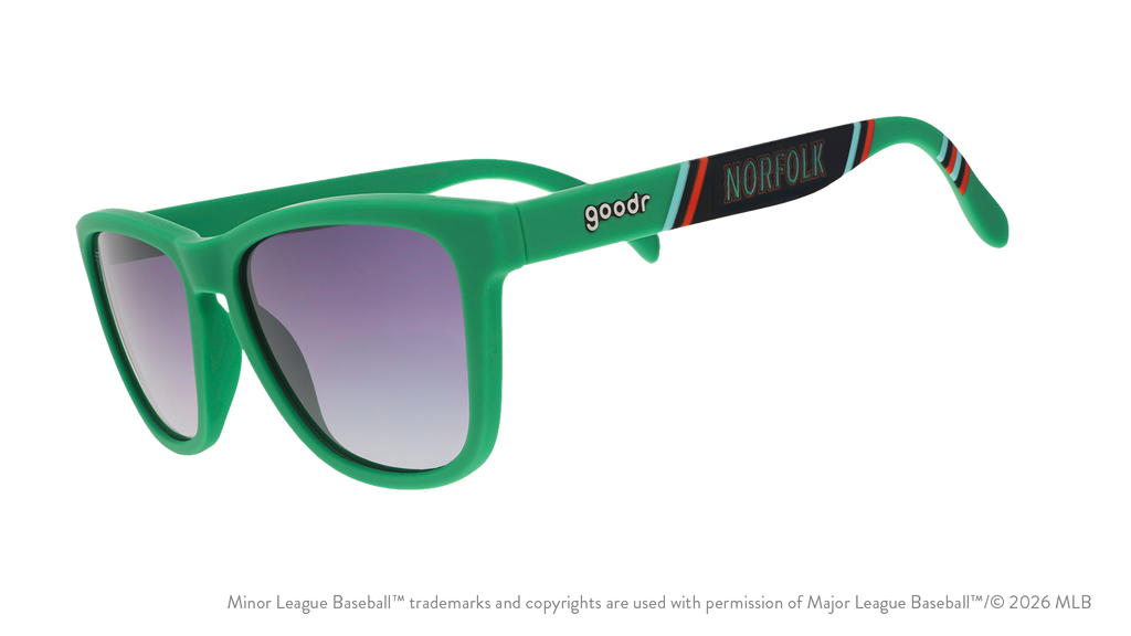 Three-quarter angle view of sunglasses. Green frames w/ a stripe pattern + Norfolk on temples. Black gradient lenses.