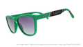 Three-quarter angle view of sunglasses. Green frames w/ a stripe pattern + Norfolk on temples. Black gradient lenses.