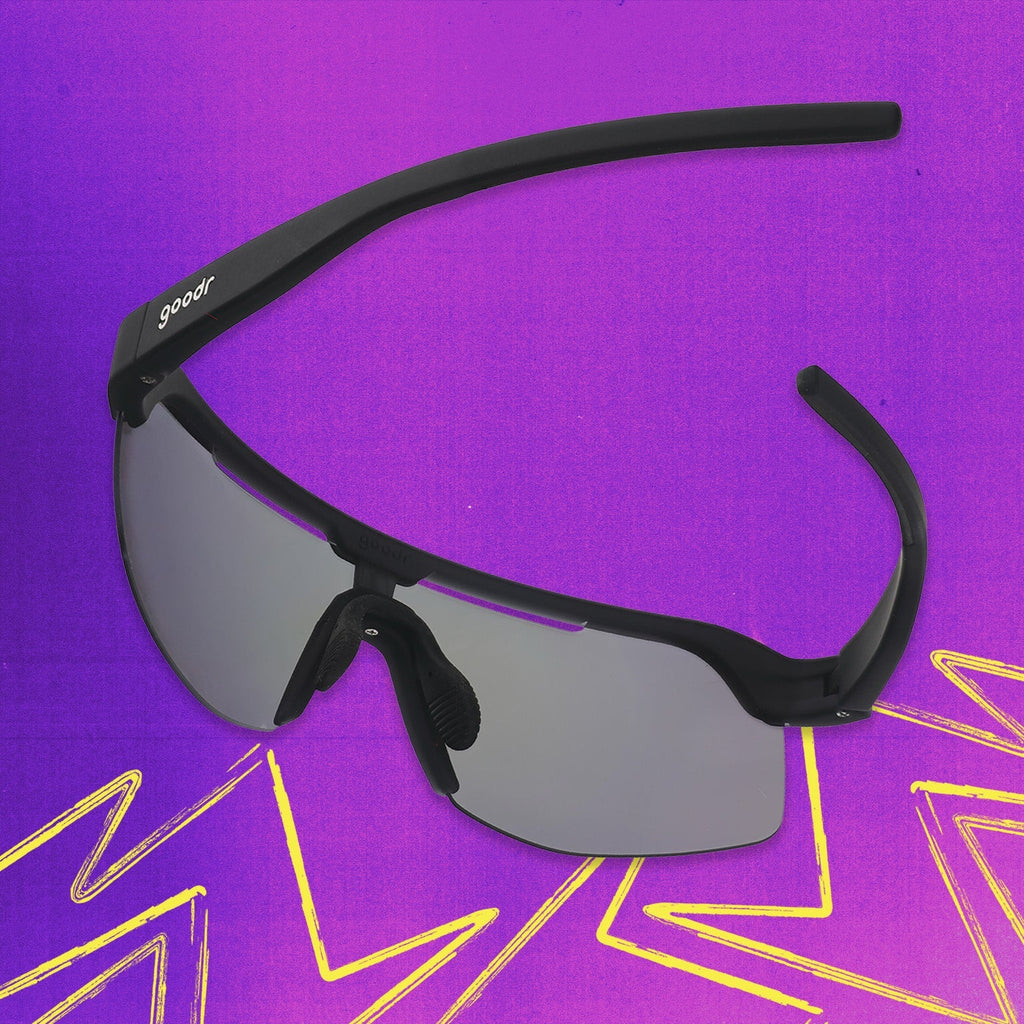 Back view of black shield sunglasses with purple reflective wrap lenses tilted down on a purple background.