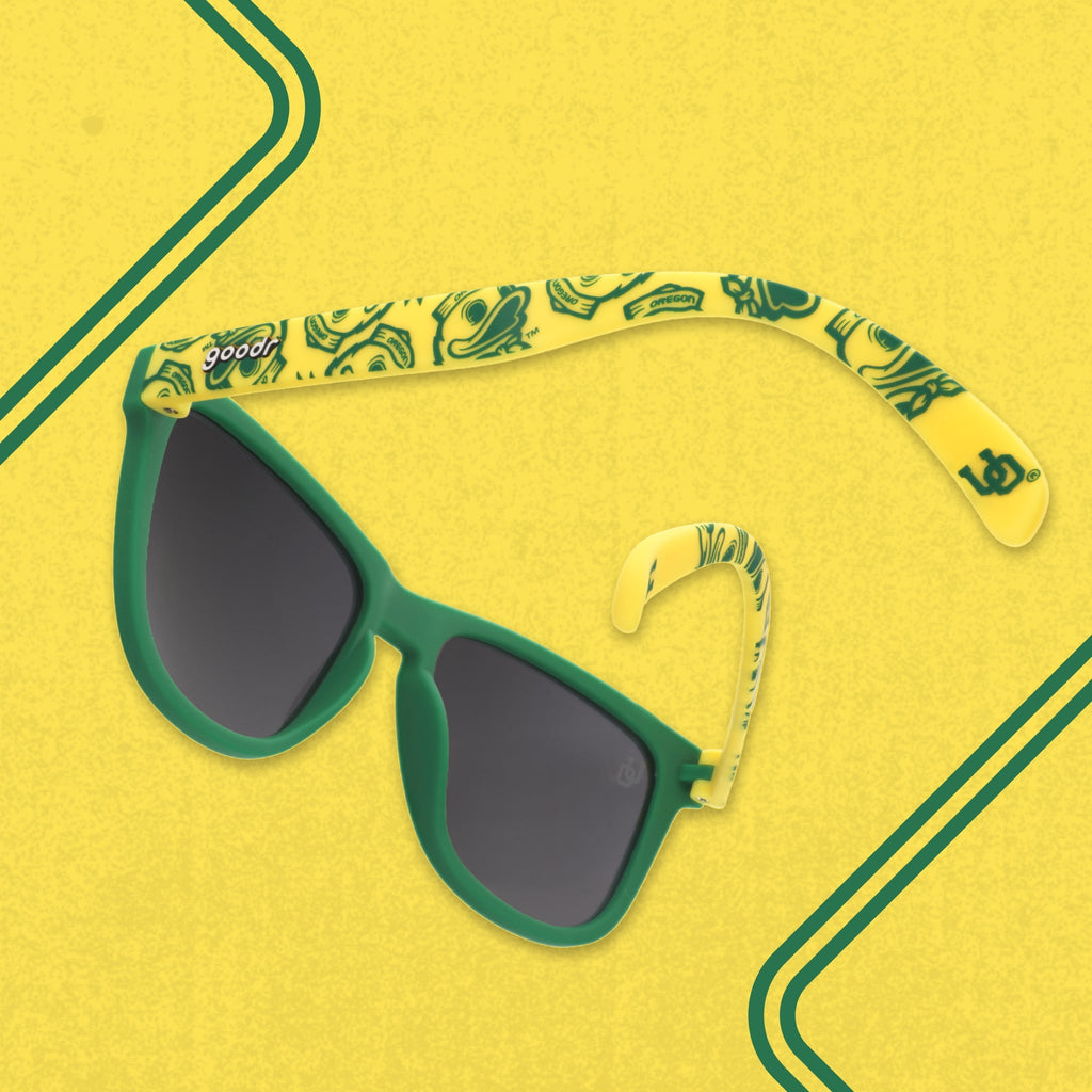 Yellow-and-green Oregon Ducks sunglasses are photographed from behind and shown against a yellow backdrop.
