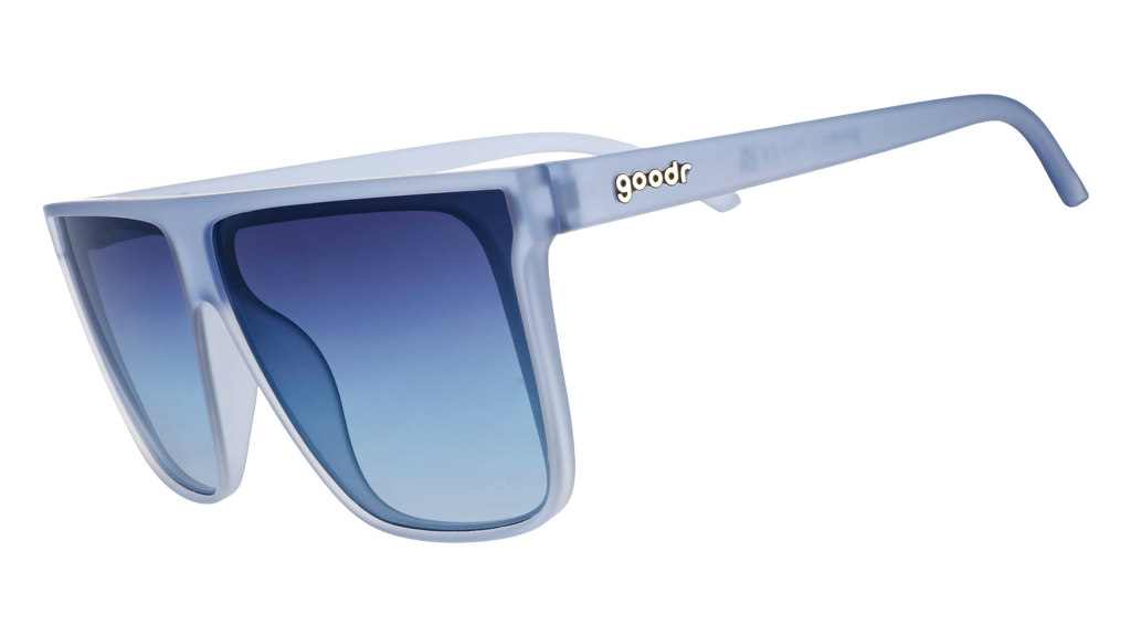 Three-quarter angle view of oversized, dusty blue Fly G sunglasses with blue gradient lenses.