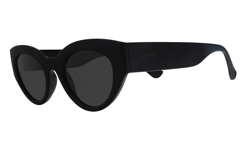 Three-quarter angle view of translucent black, retro-inspired angled cat-eye sunglasses with non-reflective lenses.