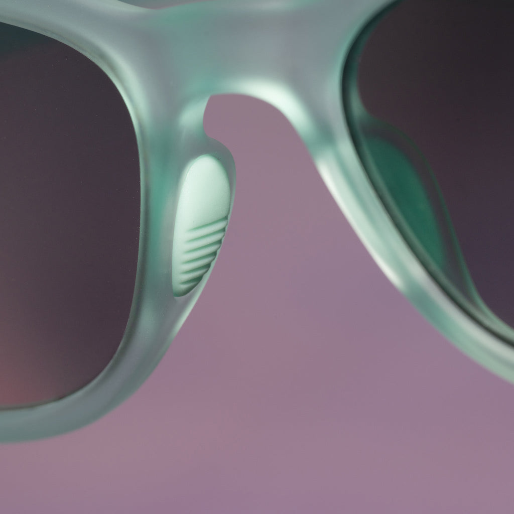 Close-up view of the silicon nose grippers on a pair of pale green Cheetah G sunglasses with green gradient lenses.