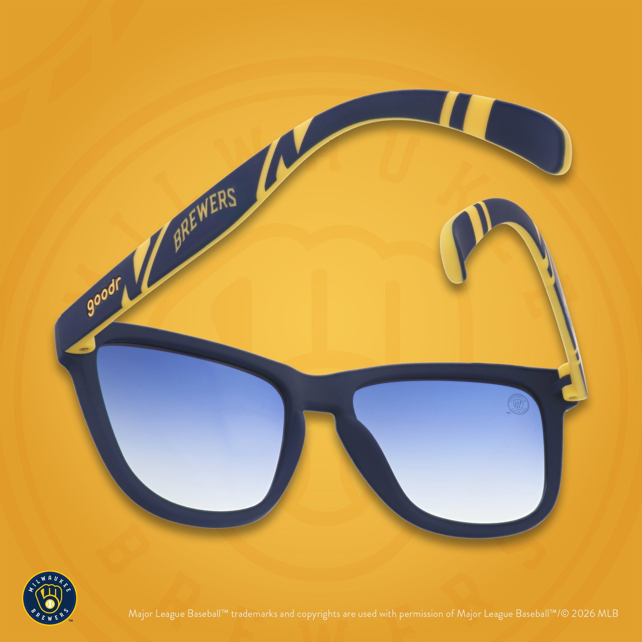 Navy and yellow shades photographed from behind, floating against a gold background featuring the ball-in-glove logo.