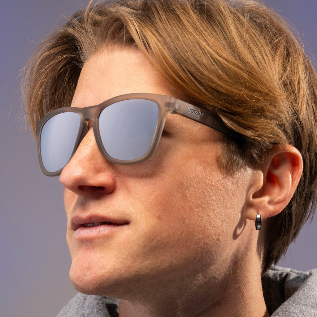 Close-up of a person wearing sunglasses with a blurred background