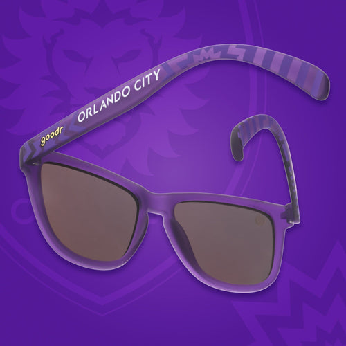 Back view of sunglasses tilted down. Purple frames w/ stripes + Orlando City on temples. Violet reflective lenses.