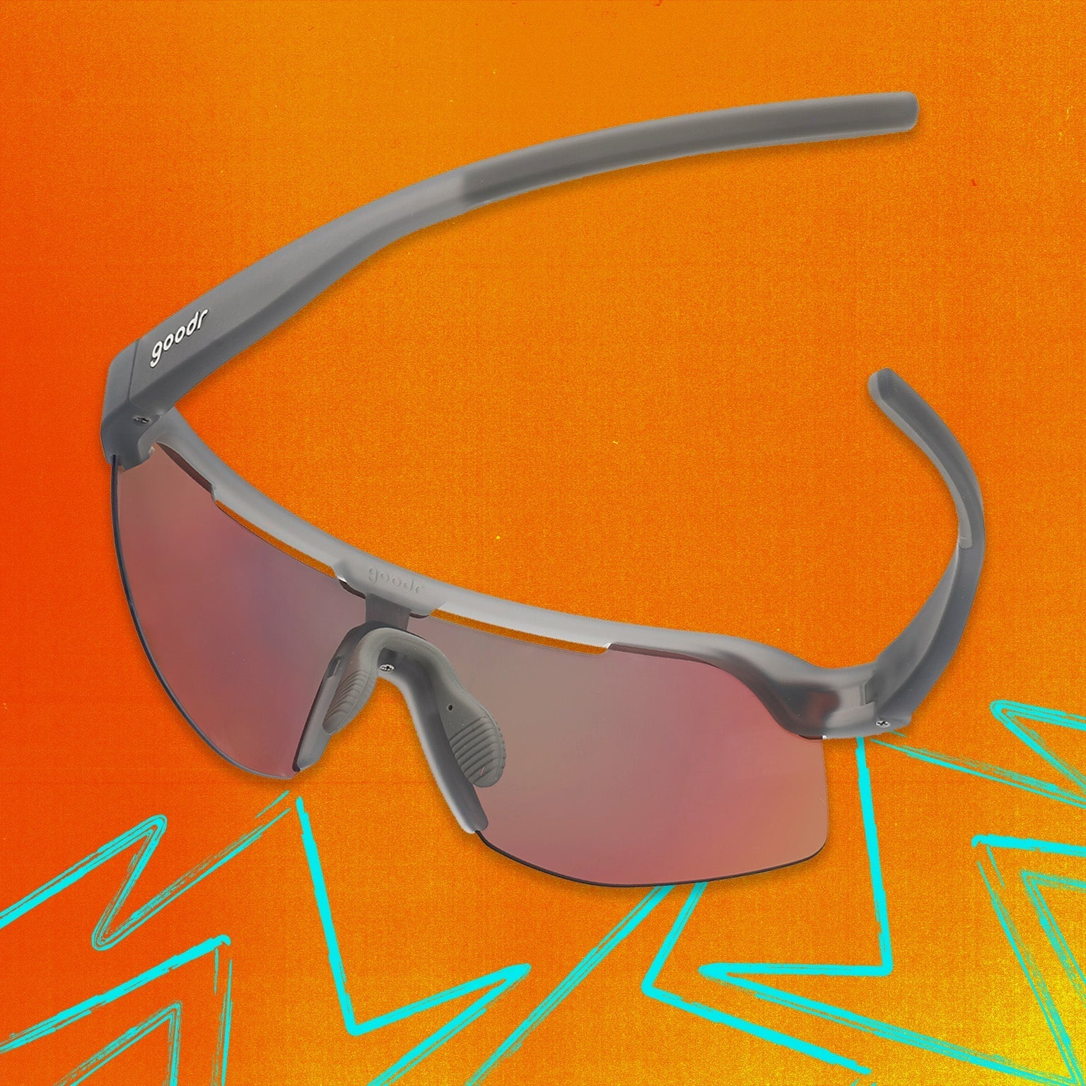 Back view of gray shield sunglasses with orange reflective wrap lenses tilted down on an orange background.