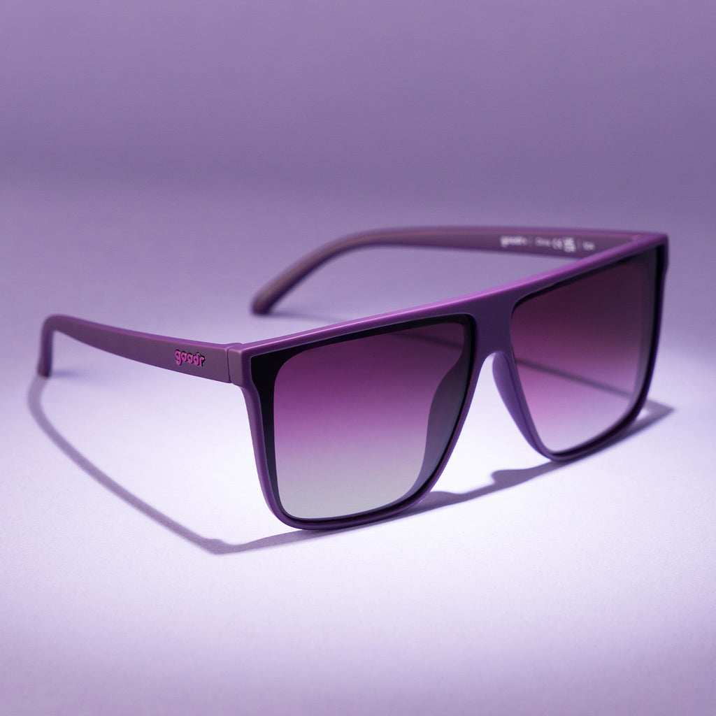 Three-quarter angle view of oversized, dark purple flat-top sunnies with deep purple gradient lenses.