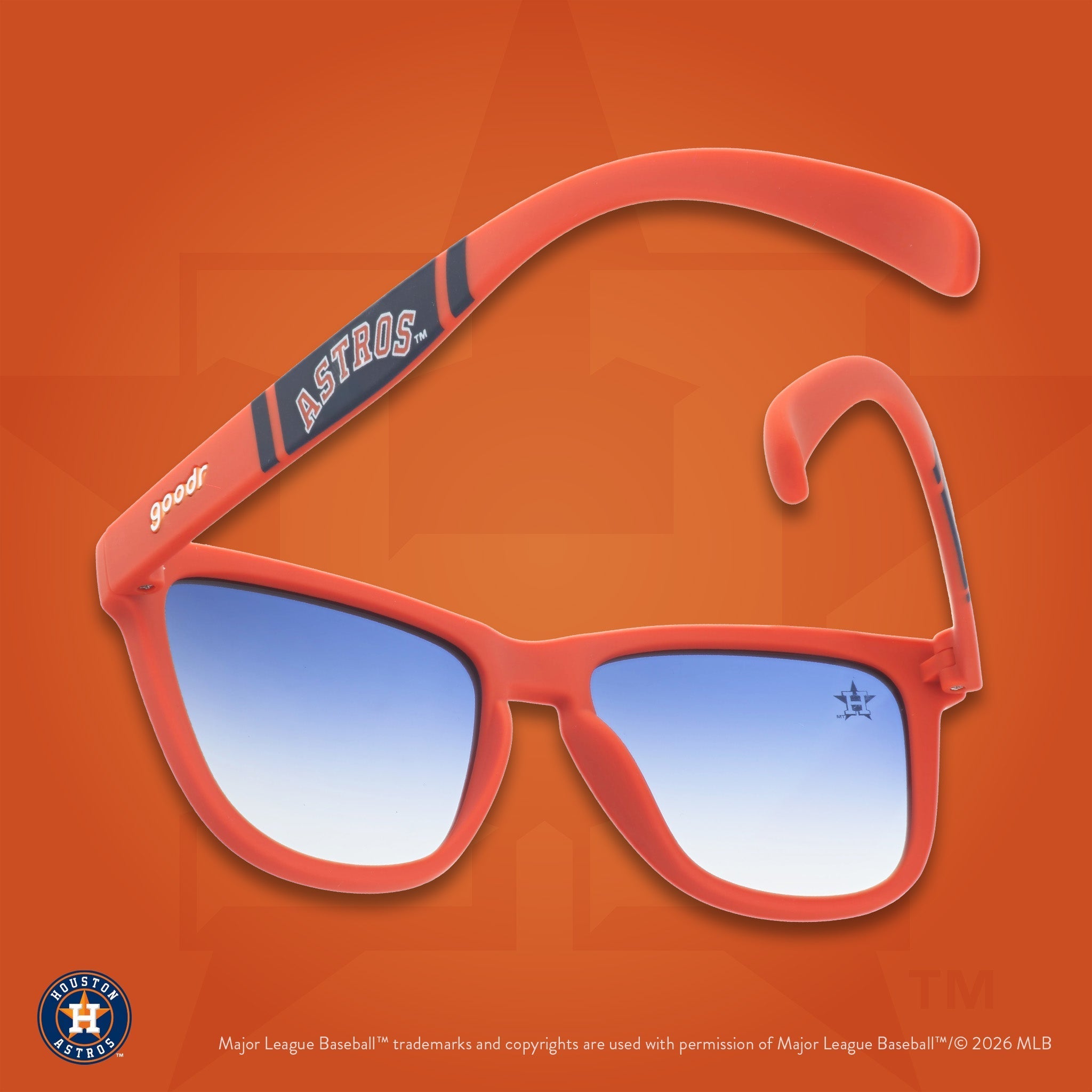 Orange and navy Astros shades photographed from behind, floating against an orange background featuring the Lone Star H logo.