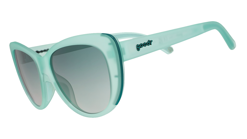 Three-quarter angle view of translucent pale green Glam G cat-eye sunglasses with  green gradient lenses.