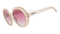 Three-quarter angle view of oversized round beige sunglasses with purple gradient lenses against a white background.