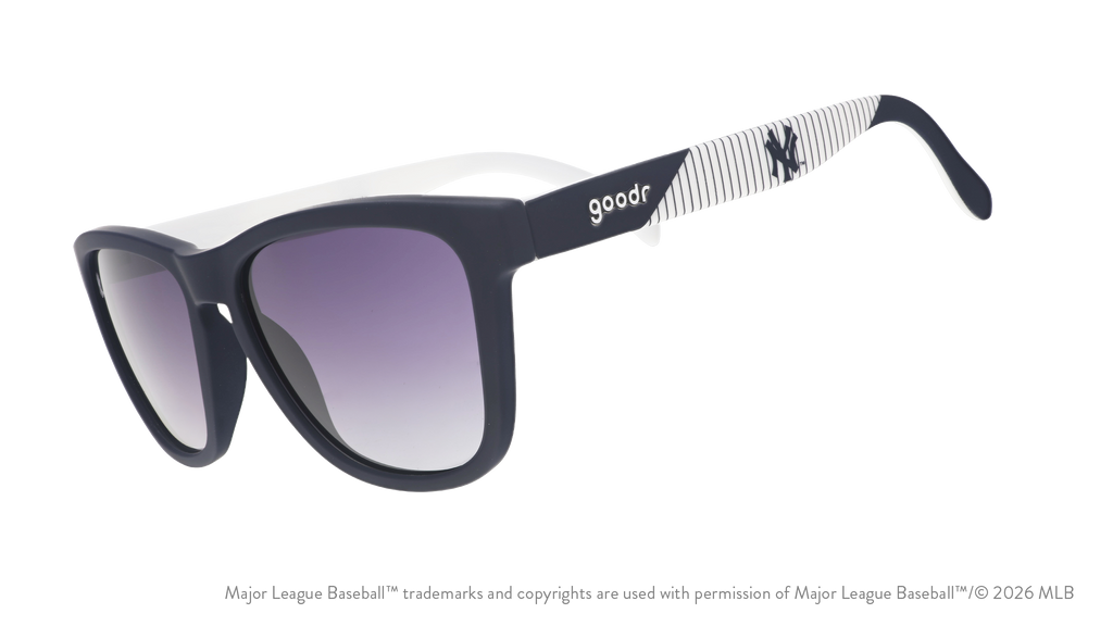 Three-quarter angle view of blue and orange Mets sunglasses featuring the script logo and a New York City skyline on the arm.