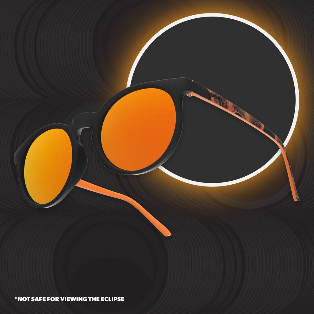 Orange and black round sunglasses with reflective orange lenses against a gray background.