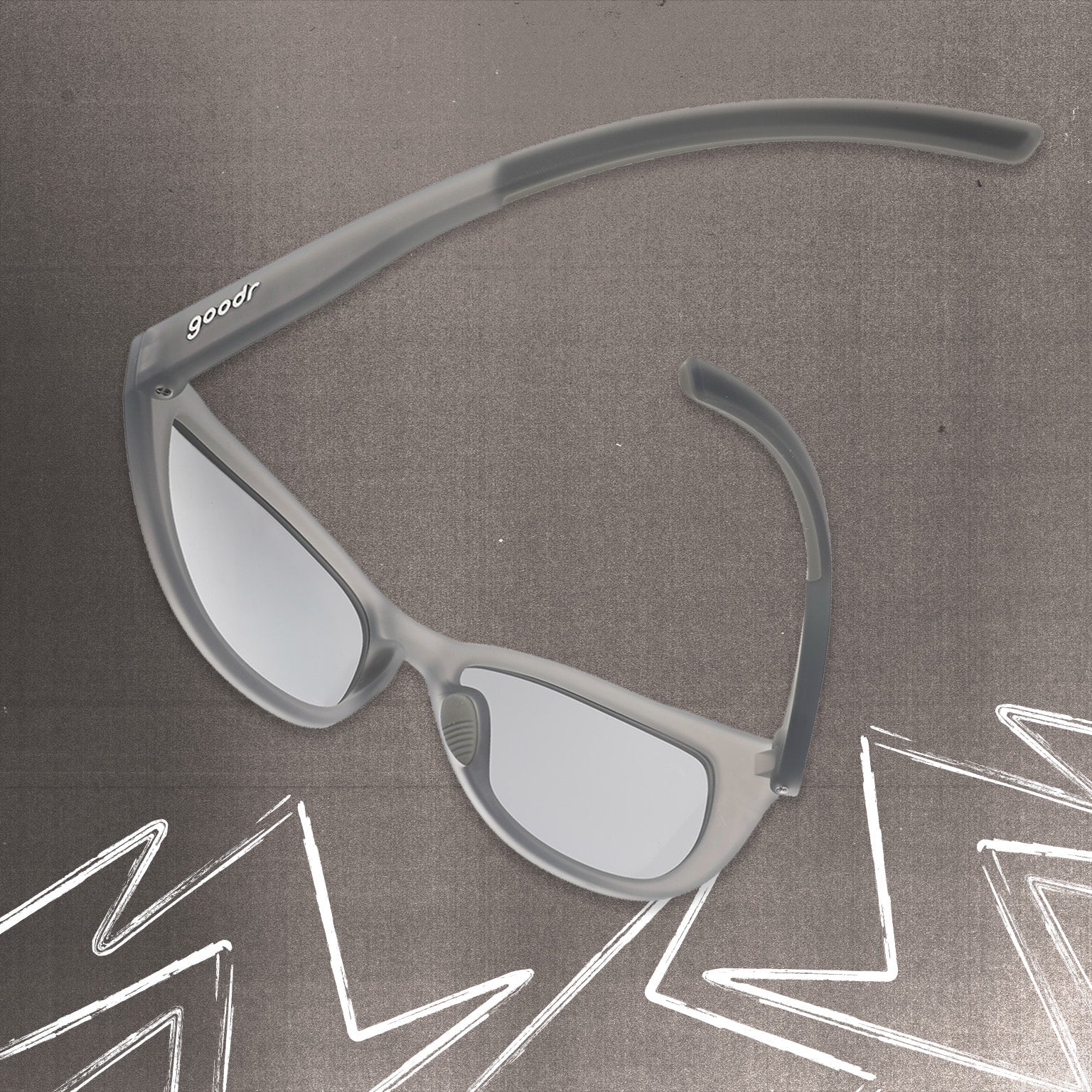 Back view of gray cat eye shades with chrome lenses tilted down on a gray background.
