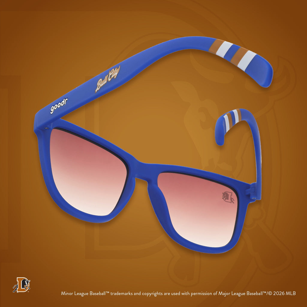 Back view of sunglasses tilted down. Blue frames w/ stripe pattern+Bull City on temples. Brown gradient lenses.