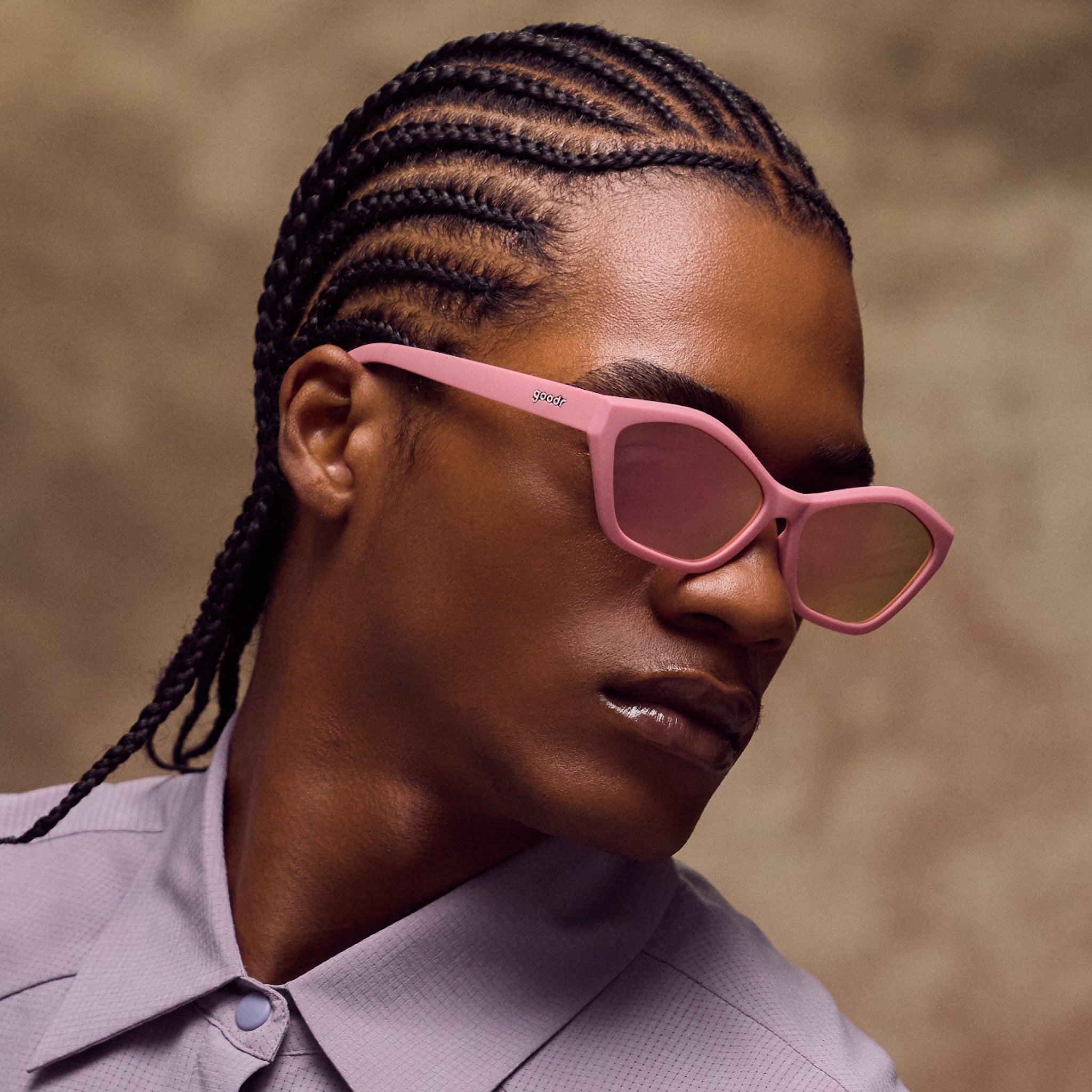 Person wearing pink sunglasses with a neutral background