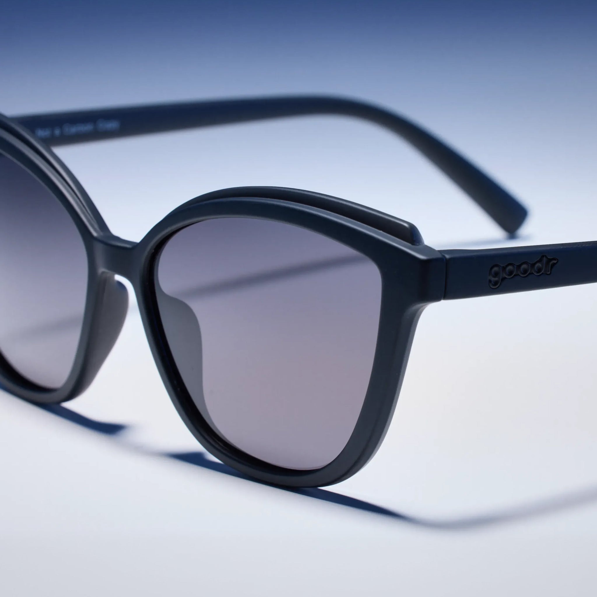 Black sunglasses with a blurred blue and white background
