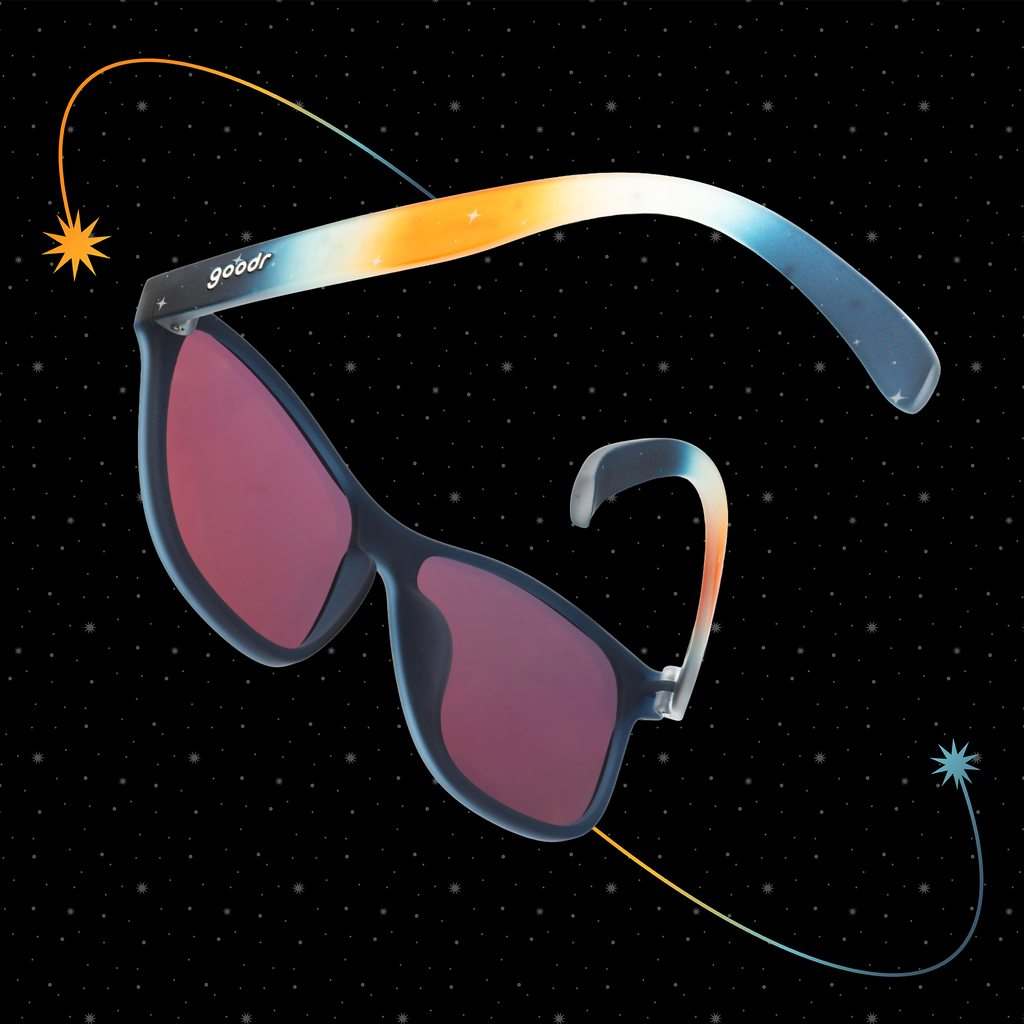 Translucent blue-orange ombre VRG frames featuring a cosmos design, photographed from behind with a starry black background.