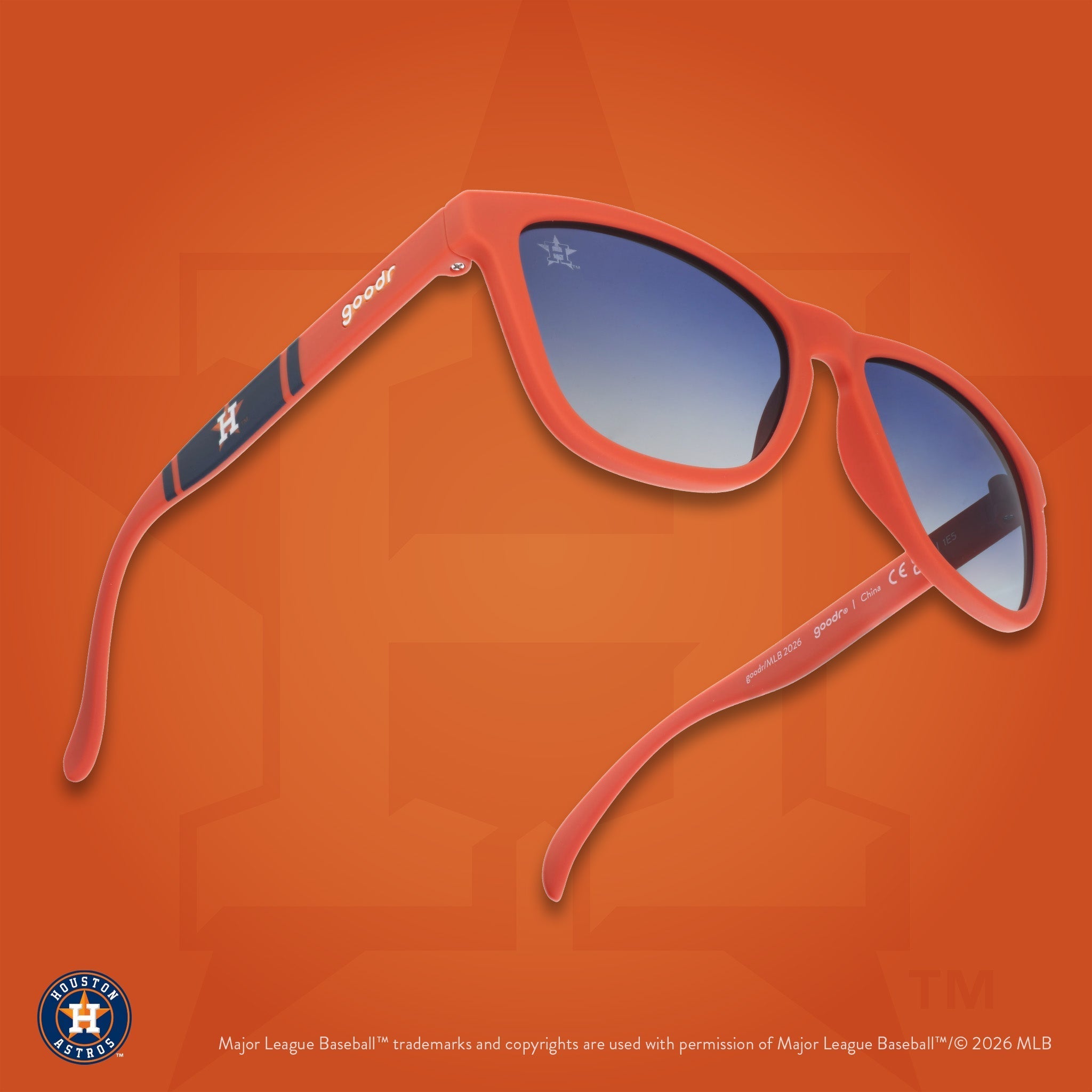 Three-quarter angle view of a pair of orange and navy sunglasses against an orange background featuring the Lone Star H logo.