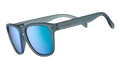 Three-quarter angle view of square-shaped sunglases with a gray translucent frame and green reflective lenses.