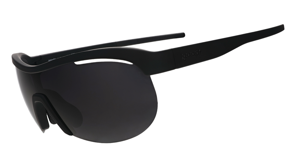 Three-quarter angle view of black wrap shield sunglasses with black polarized lenses against a white background.