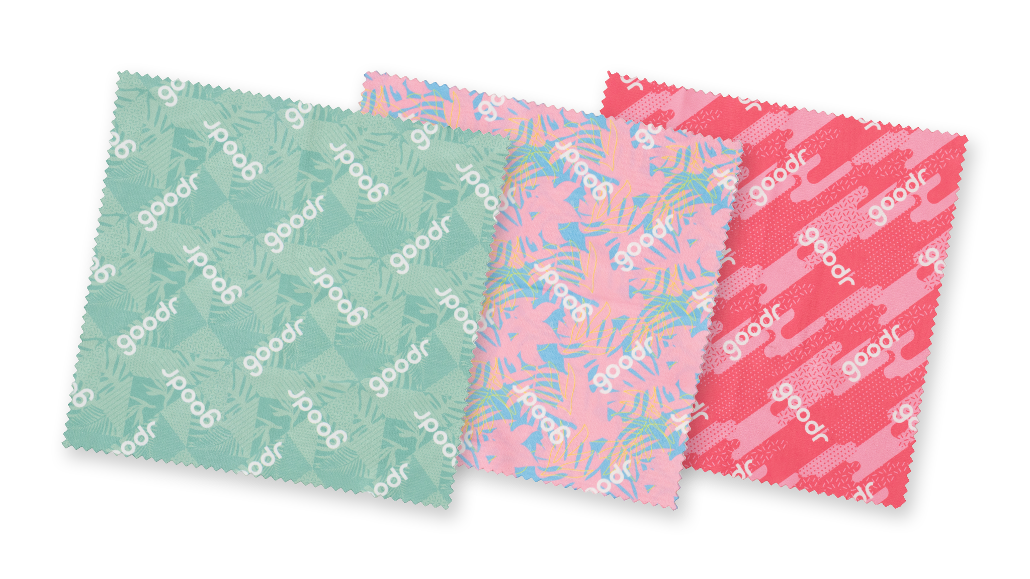 Close-up of a pack of three tropical microfiber lens cloths in shades of pink and teal on a teal, geometric tropical backdrop.
